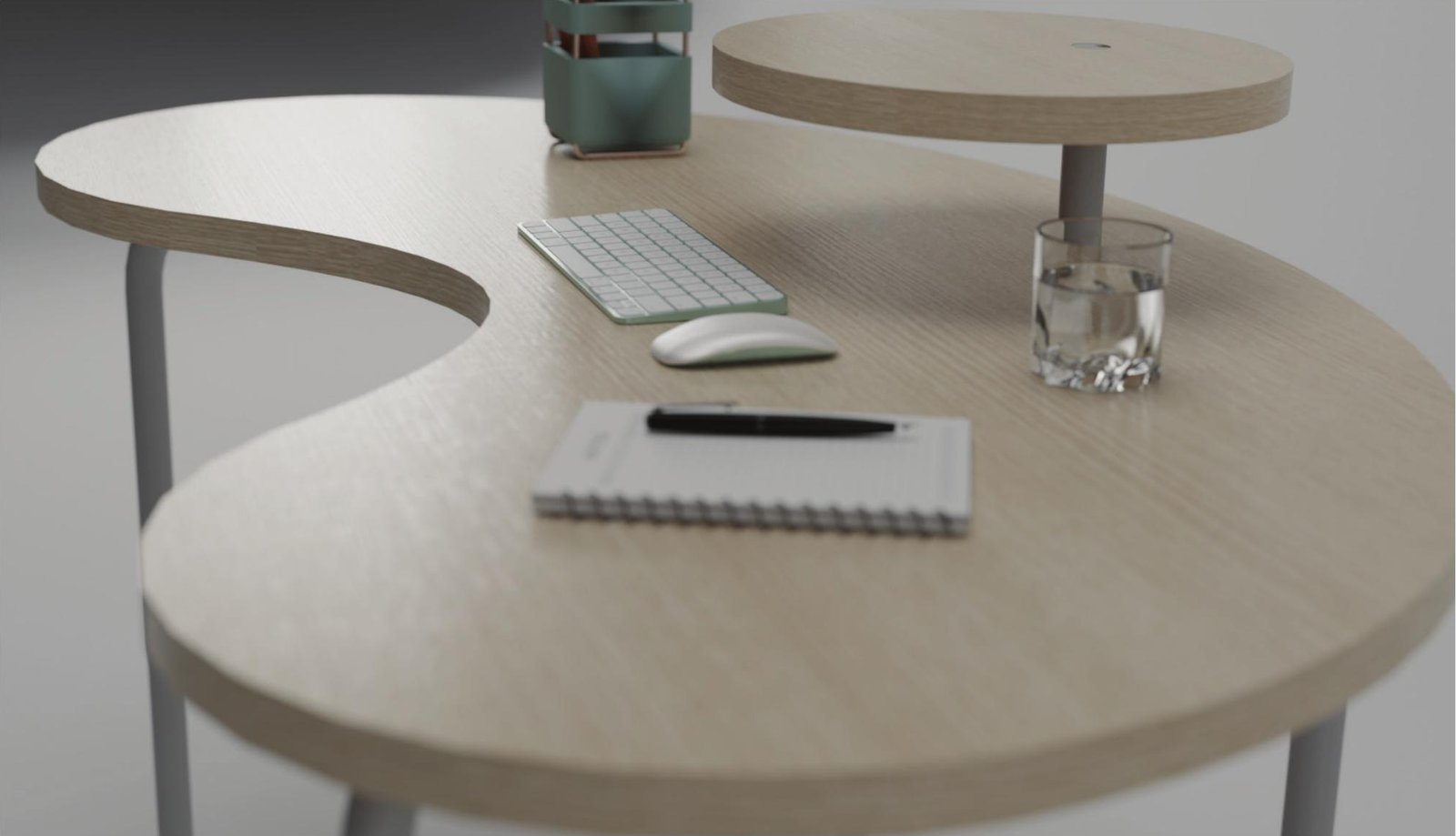 Overhead detail of the Kidney Desk showing the raised laptop platform, keyboard, mouse, and notepad on an oak veneer surface